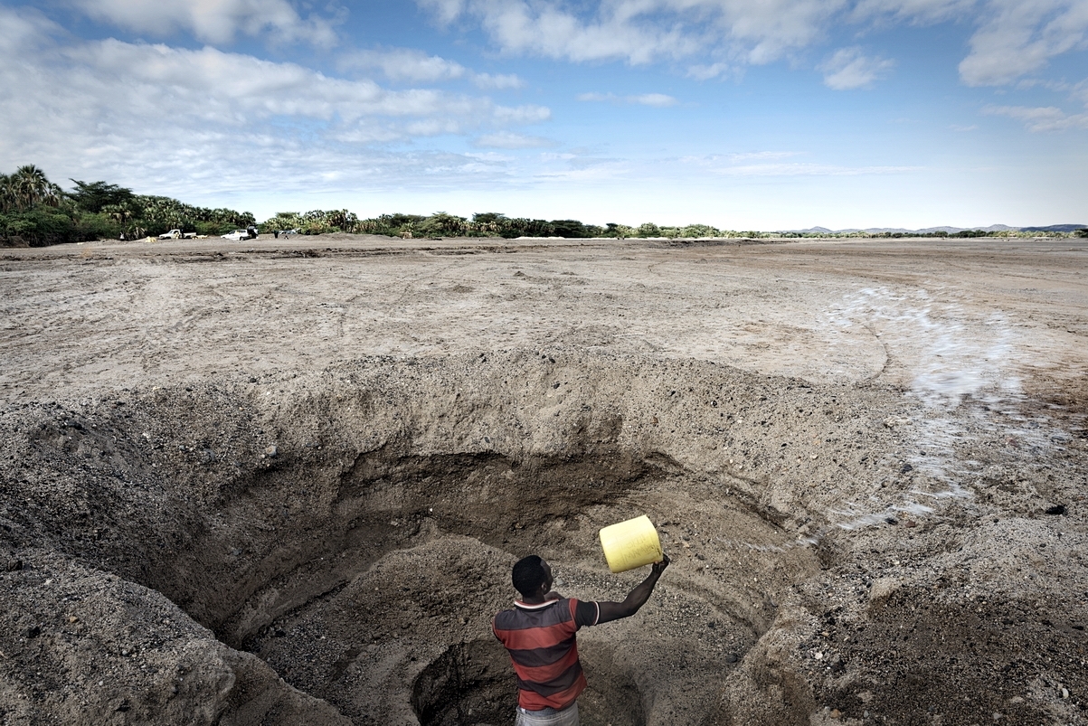 Kenya, Turkana County, 19th May 2017, Kalokol river – A man digs a hole to reach drinking water. During the drought the inhabitants of this area must dig deep holes (about 3 meters) in order to take drinking water from the kalokol river that flows undergro